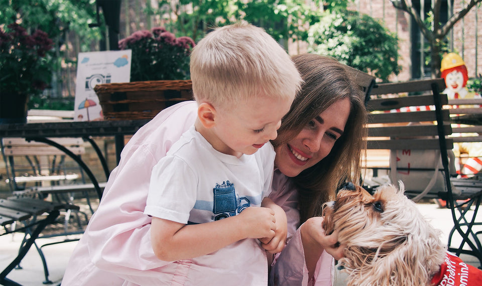 Mom and son enjoy a volunteer's therapy dog during an event outside at RMH-NY