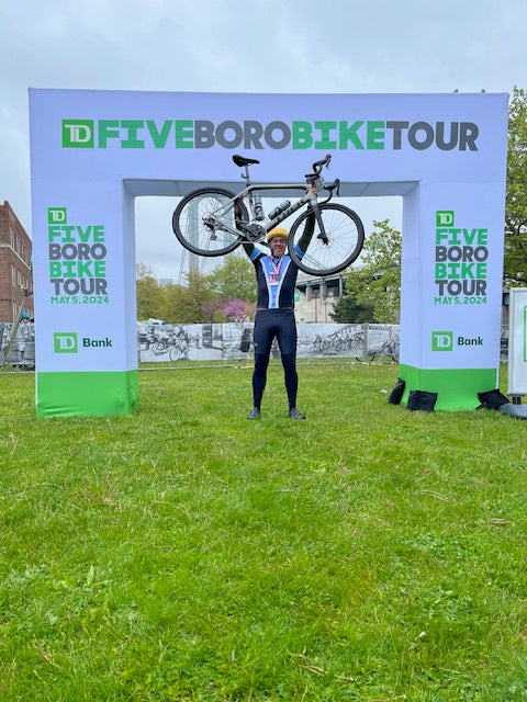 Neil B loomgarden holding up a bike at the end of the 5 Boro Bike Tour riding for Ronald McDonald House New York