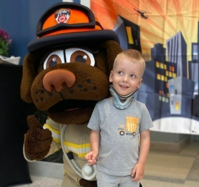 boy smiling next to cartoon character
