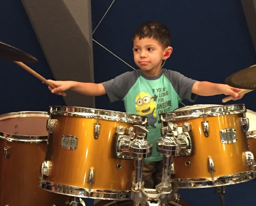 little boy playing drums