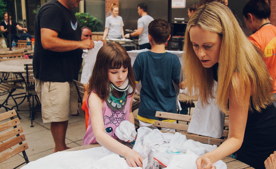 Ronald McDonald House New York volunteer helps a child with cancer find to right puzzle piece for the game.