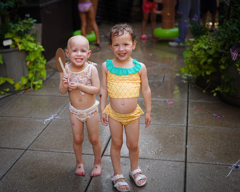 Ruby and Beatrix in the sprinklers at the Fourth off July celebration on the 3rde floor terrace