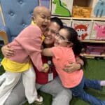 Stefanie with Mavis and another child in the House hugging hard