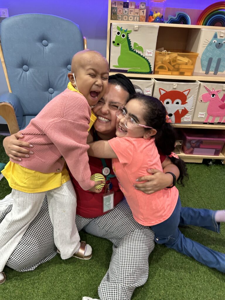 Stefanie with Mavis and another child in the House hugging hard