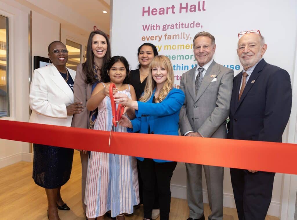 Melissa Rauch joins the leadership at Ronald McDonald House New York in the Community Floor to cut the ribbon on with a family from the House.