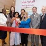 Melissa Rauch joins the leadership at Ronald McDonald House New York in the Community Floor to cut the ribbon on with a family from the House.